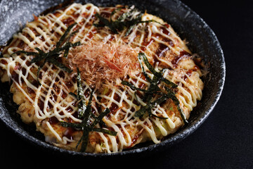 Okonomiyaki traditional japanese food isolated in black background