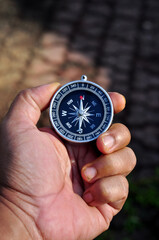 Hand holding a compass with blur background