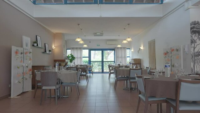 Dining room and tables set with glassware and dishes in the nursing home, a comfortable and cozy place