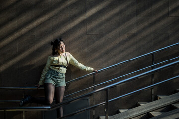 Portrait of a young Asian woman posing in the subway near the stairs. 