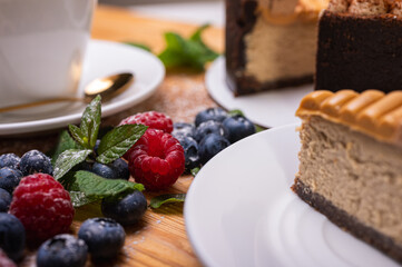 close-up of a light cup with coffee, macaron with cream filling, decorated with fresh berries, blueberries and raspberries, festive New Year's cake, Christmas