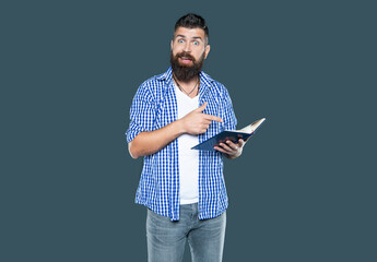 surprised bearded man reading book on grey background