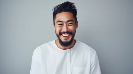 Tuinposter Happy young asian man with beard and stylish hairstyle. Positive expression studio portrait. AI generated. © 0livia