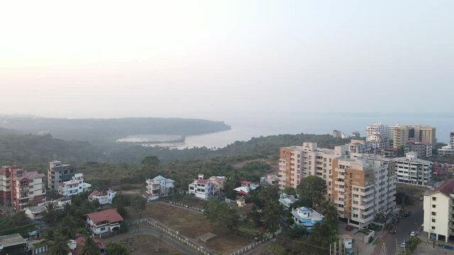 Drone footage of Buildings | Trees with beach behind them | Goa, India