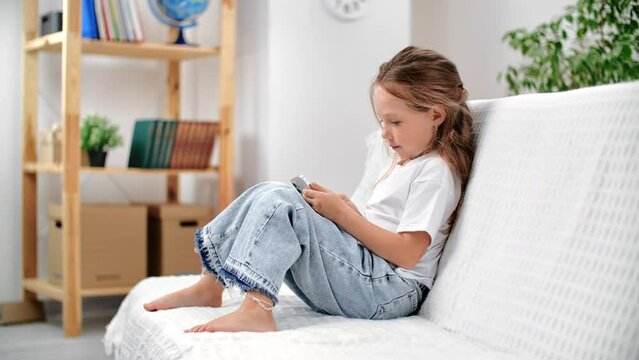 Modern little girl use smartphone browsing social network playing virtual digital game application