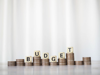 Wooden blocks with the word BUDGET on stack of coins. The concept about budget planning and...