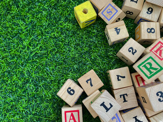 Colorful wooden cubes with numbers scattered on green grass background. learning, increase IQ, development for children. Top view of children's toys. Educational game.