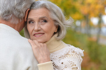 happy senior couple standing in autumn park