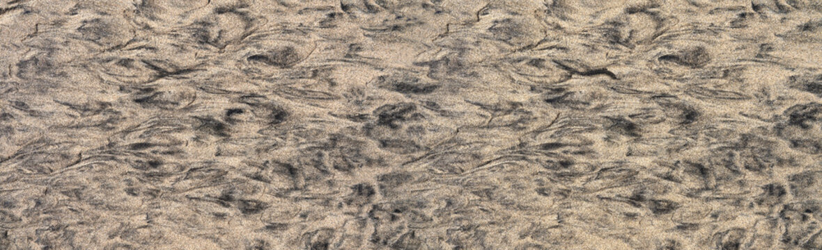 Abstraktes Muster aus schwarzem und braunem Sand in einem ebenen Boden am Strand bei Ebbe, aufgenommen in Fuerteventura, Kanarische Inseln