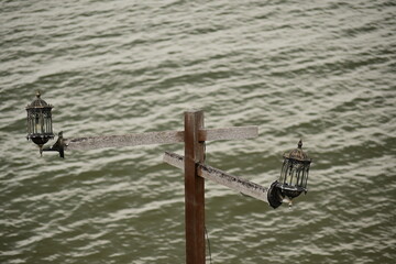 old classic style garden lamp installed on the sea pier with sea surface background