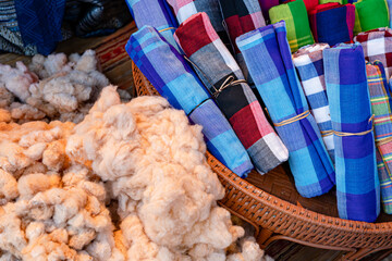 Colorful Thai Style Loincloths Fabric (Pha khao ma) folded in the basket, handicraft of local residents of Thailand, traditional made from cotton or silk.