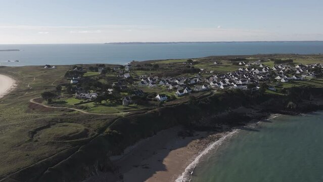 Fontaine beach in the island of Houat in France on the Atlantic Brittany coast with village, Aerial pan left wide shot