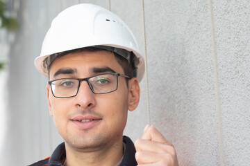 technician male with helmet standing near a building