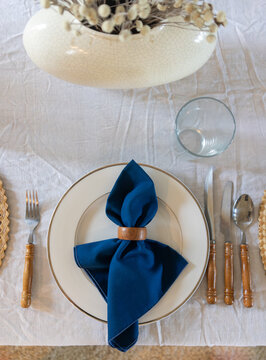 Festive white and royal blue table setting with wooden accents
