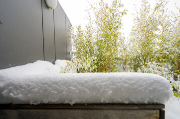 Snow-covered all-season furniture on a roof terrace