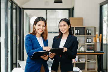 Businesswoman leading team meeting and using tablet and laptop computer with financial in office