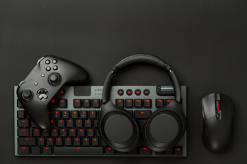 Gaming concept on black background with computer keyboard and joystick