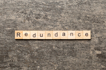 redundance word written on wood block. redundance text on table, concept