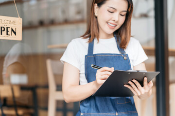 Opening a small business, Happy Asian woman in an apron standing to take orders, Small business...