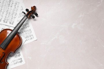 Violin and music sheets on grey marble table, top view. Space for text