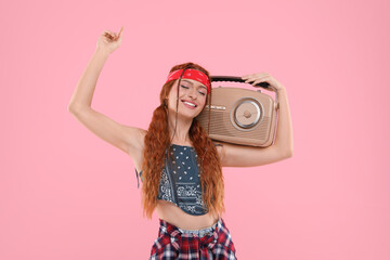 Stylish young hippie woman with retro radio receiver on pink background