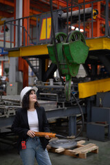 Female engineer inspects a weightlifting jack at a heavy industrial warehouse. Smart industrial...