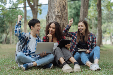 Happy group of college students use laptop feel excited overjoyed triumph with good news over...