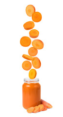 Baby food. Slices of fresh carrot falling into jar of puree on white background
