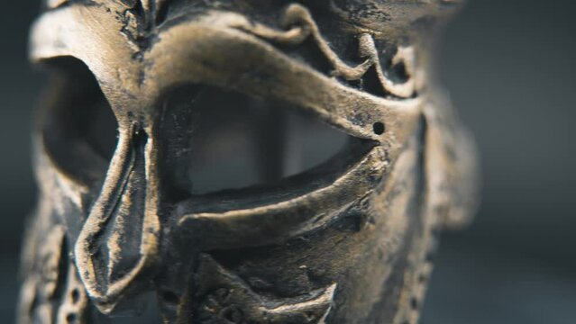 A close up macro detailed shot of a spartan face design, warrior ancient greek bronze helmet, on a 360 rotating stand, studio lighting, 4K smooth movement