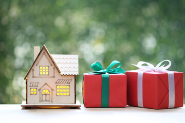 Real estate and Gift new home concept,Model house and gift box with ribbon for Christmas and New...