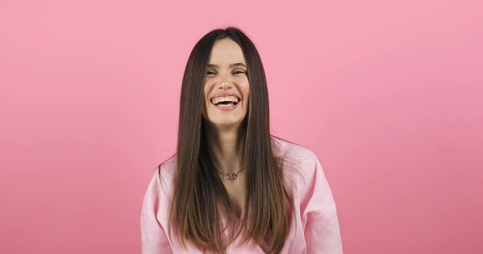 Amazed excited woman hairstyle in pink dress open mouth in surprise looking at camera with big eyes, shocked isolated on pink background. Oh my god wow, yes gesture, win symbol. 