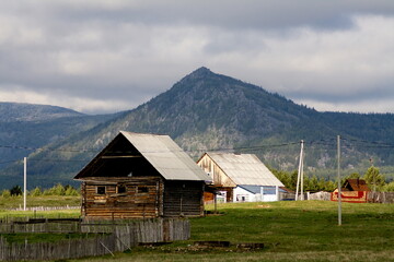 the village of Verkhnearshinsky in the Beloretsk region of Bashkortostan against the backdrop of the Kumardak ridge on a cloudy day