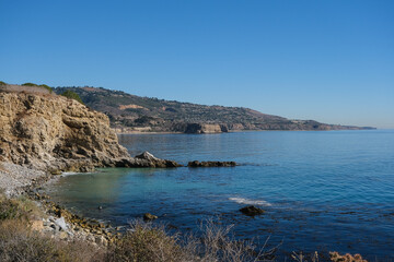 Fototapeta na wymiar Breathtaking scenic and landscape view of coastline of Rancho Palos Verdes with vegetation and cliffs and beautiful bays overlooking ocean and coast in California on sunny blue sky day