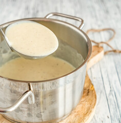 vanillesauce in einem topf mit schöpfer 