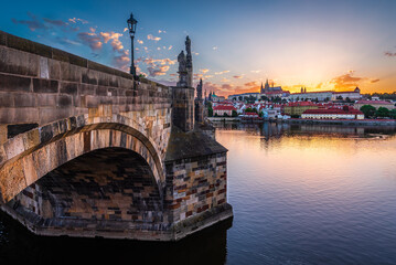 Fototapeta na wymiar The UNESCO world heritage site Charles Bridge and Prague castle on the summer solstice day when sun sets behind the castle.