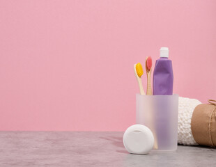 Organic biodegradable toothbrushes and purple tube of toothpaste. A container of dental floss and a...