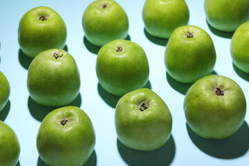 Ripe green apples on light blue background, closeup