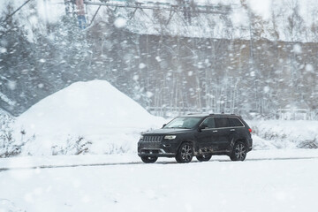 SUV car moves on the winter road highway. Family trip to the winter holidays adventure. Truck on...