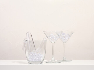 Detail of cocktail party table. Glass ice bucket and glasses with ice for alcohol drinks.