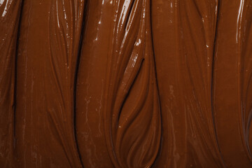 Tasty milk chocolate paste as background, top view