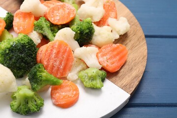 Mix of different frozen vegetables on blue wooden table, closeup