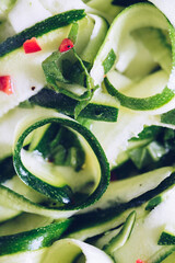Healthy salad with fresh zucchini, mint and hot chilli pepper on a white plate