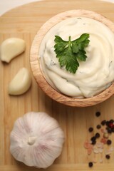 Tasty sauce with garlic and parsley on wooden table, top view