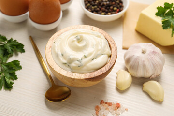 Tasty sauce with garlic and ingredients on white wooden table, closeup