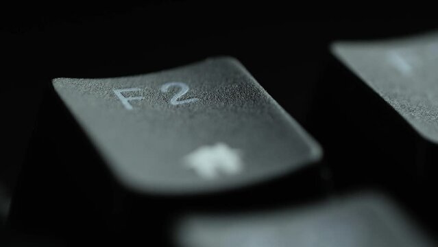 Keyboard button F2. Macro shot of finger pressing F2 button