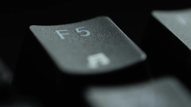 Keyboard button F5. Macro shot of finger pressing F5 button