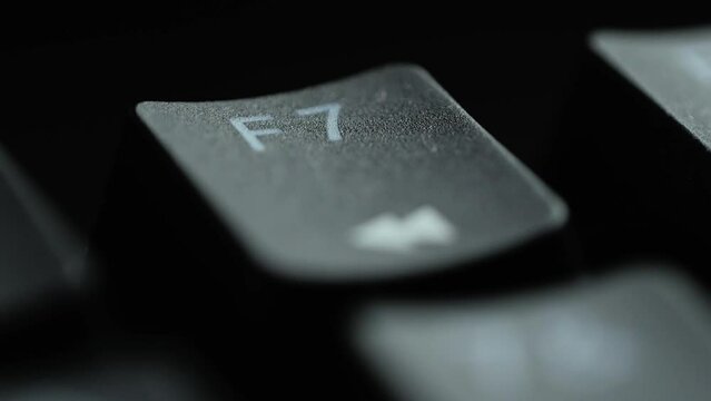 Keyboard button F7. Macro shot of finger pressing F7 button