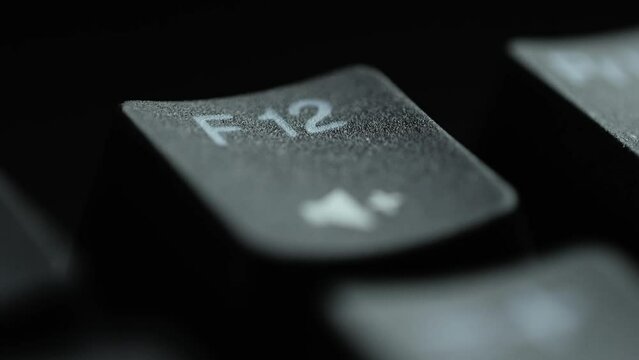 Keyboard button F12. Macro shot of finger pressing F12 button
