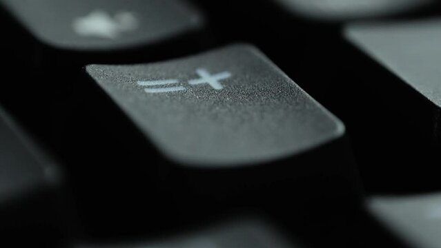 Keyboard button PLUS. Macro shot of finger pressing EQUALS button