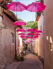 Street displaying pink umbrellas, for Pink October, in Chanaz, Savoie, France